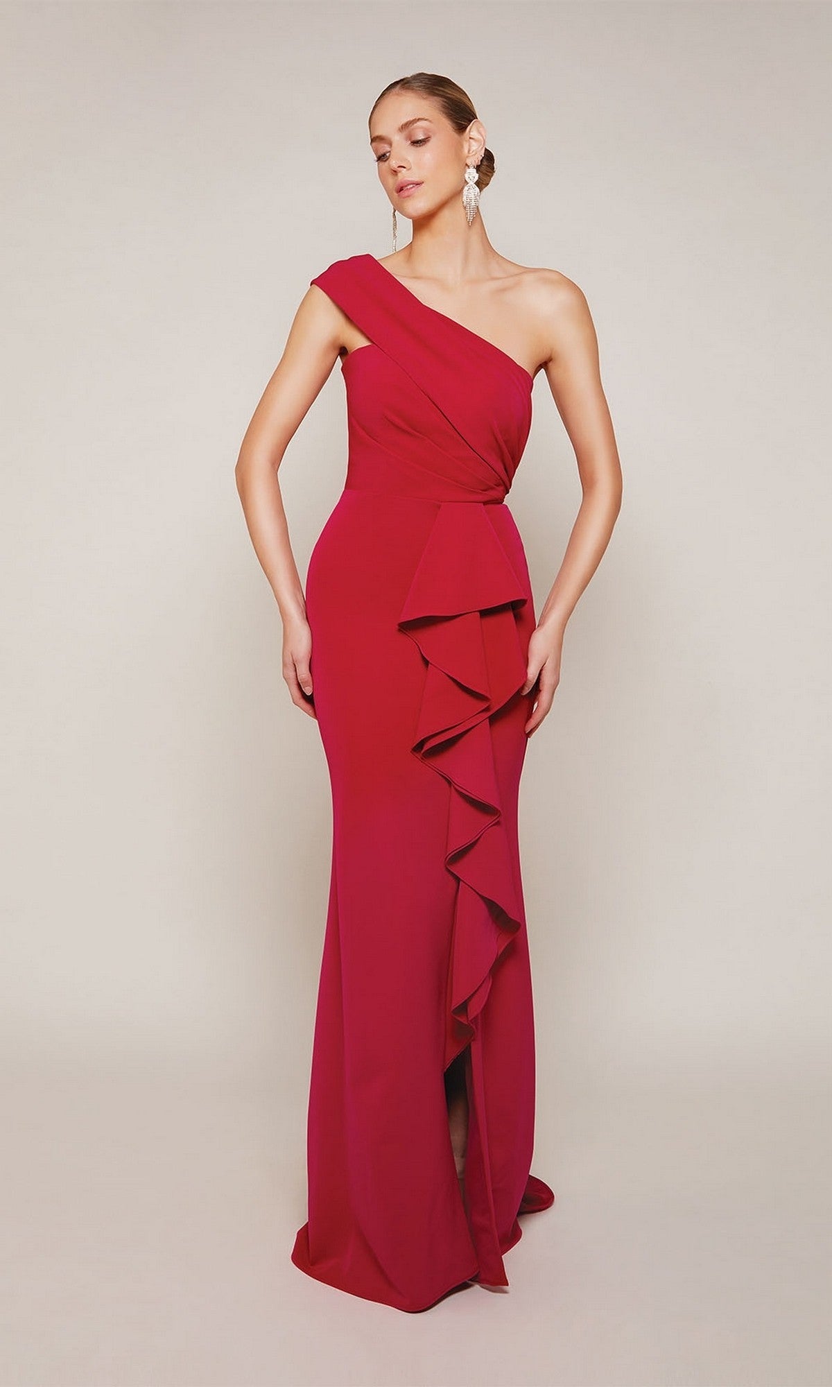 A person wearing the Alyce 27646 Long Formal Dress, a floor-length, one-shoulder formal gown with front ruffled detail and a chic sheath silhouette, poses against a plain light background.